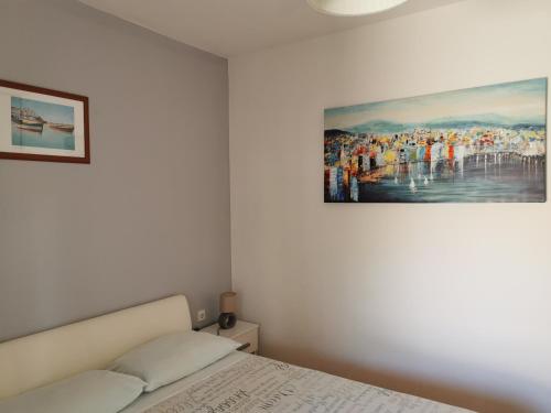 a bedroom with a bed and a painting on the wall at Apartments Mira in Bibinje