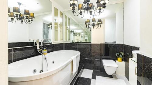 uma casa de banho com uma banheira, um WC e um lustre em COZY LUXURY 3 BRM 4 BED em Durban