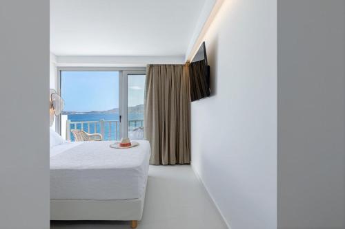 a bedroom with a bed and a large window at Boho Sapiens Seagnature in Adamantas