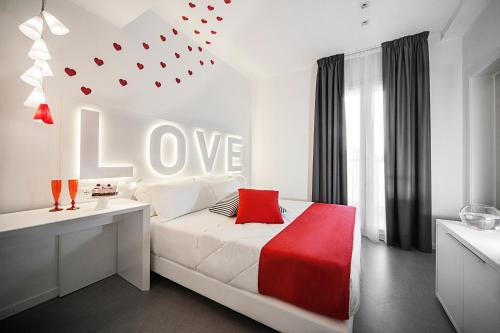 1 dormitorio con 1 cama con una señal de amor en la pared en Love Boat Hotel - The Original en Riccione