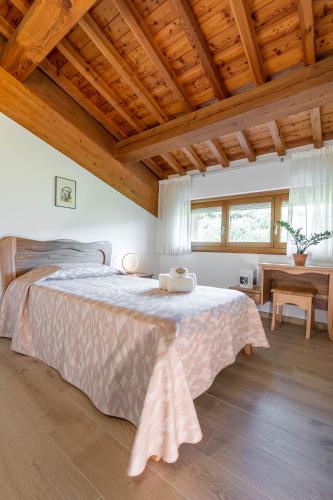 a bedroom with a large bed with a wooden ceiling at Agriturismo Ai Dossi in Verona