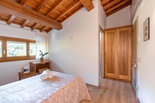 a bedroom with a bed and a wooden ceiling at Agriturismo Ai Dossi in Verona