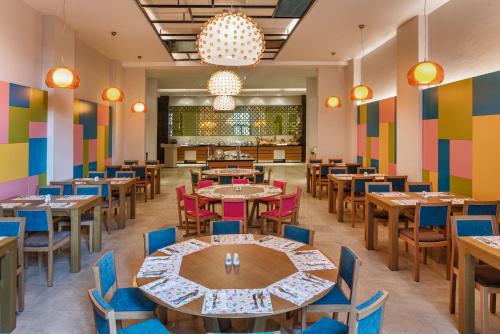 a restaurant with tables and chairs and colorful walls at Aska Lara Resort & Spa Hotel in Lara