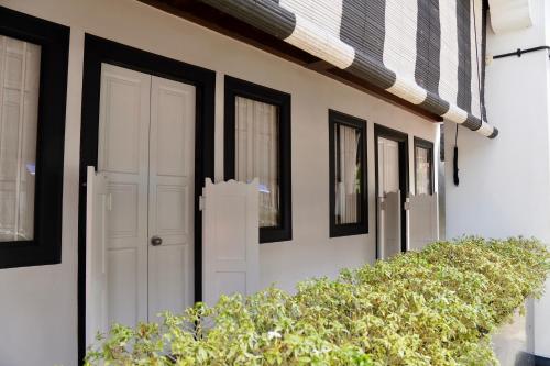 a white door on a house with black windows at Check-Inn at Little India in Singapore