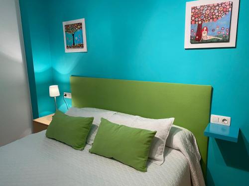 Schlafzimmer mit einem Bett mit grünen und blauen Wänden in der Unterkunft Apartamentos Alcañiz, Ana in Alcañiz