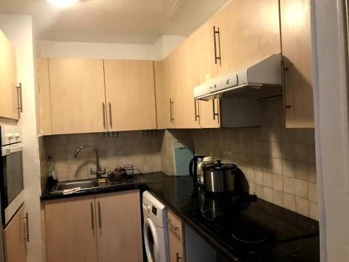 a kitchen with wooden cabinets and a sink at The beautiful corner of Copenhagen close in Luton