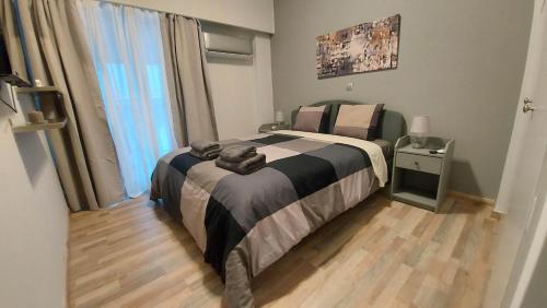 sypialnia z łóżkiem i dużym oknem w obiekcie METROPOLITAN MACVIEW-4 ΔΙΑΜΕΡΙΣΜΑ w Pireusie