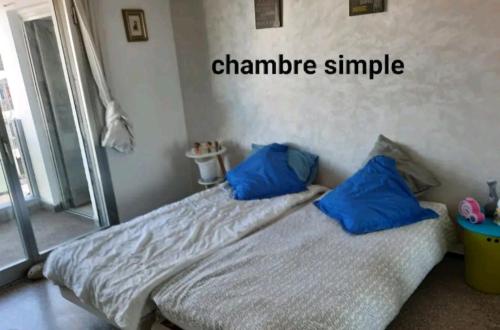 a bed with two blue pillows in a room at Appartement RIM in Casablanca