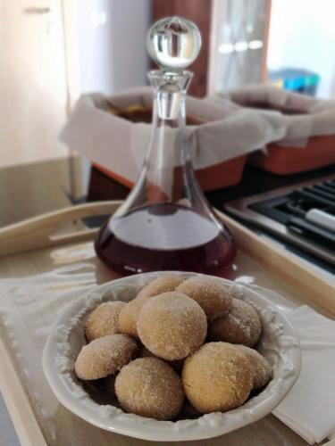 a bowl of donuts on a counter with a bottle of syrup at Poço e Meio - Padel & Pool in Santiago da Guarda