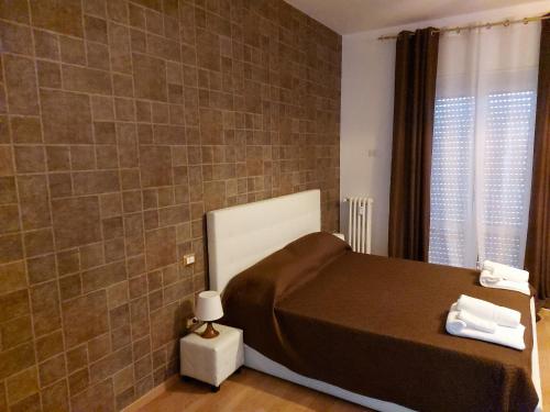 een slaapkamer met een bed en een betegelde muur bij B&B Viviani Potenza in Potenza