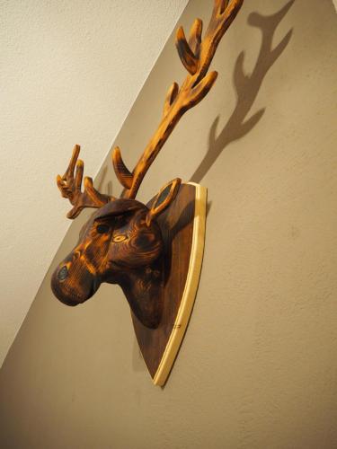 a wooden head of a reindeer hanging on a wall at Ferienwohnung Grüntenpanorama im Jägerwinkl Allgäu in Rettenberg