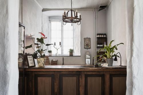 a kitchen with a counter with plants and a window at Hotel Helgeand Wisby in Visby
