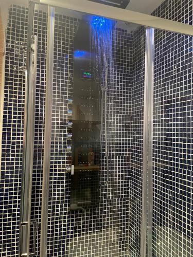 a shower with black and white tiled walls at Chale a 25 minutos de Madrid cerca de Somosierra in El Casar de Talamanca