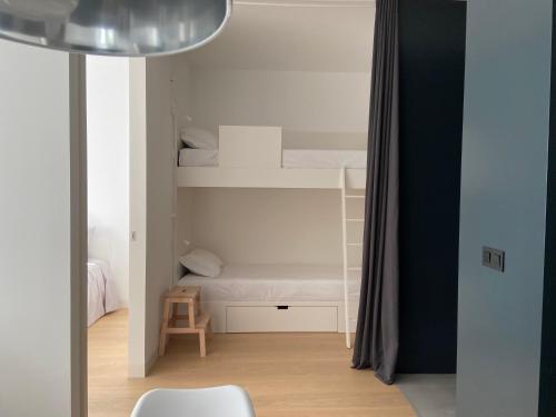 een kleine kamer met een stapelbed en een stoel bij Mus Boavista in Porto