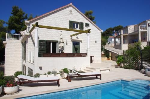 una casa con piscina delante de una casa en Holiday Home Nevista, en Sumartin
