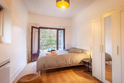 une chambre avec un lit et une fenêtre dans l'établissement La Maisonnette-Aix, à Aix-les-Bains