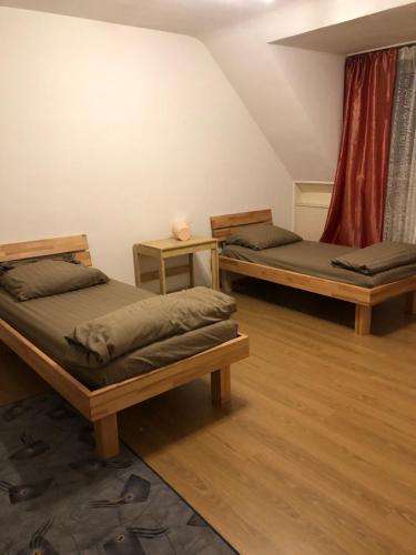 two twin beds in a room with wooden floors at Schönes Apartment in Essen in Essen