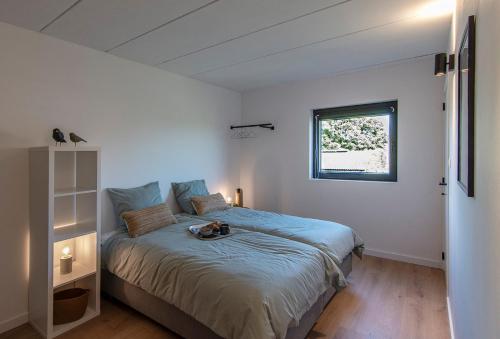 a bedroom with a bed and a window at Villa veld en velo in Bree