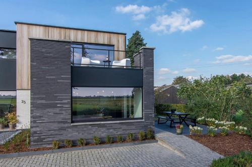 a house with a large window on the side of it at Villa veld en velo in Bree