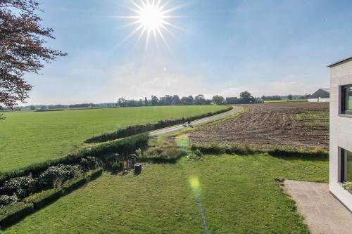 a view of a field with the sun in the sky at Villa veld en velo in Bree