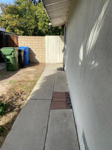 a sidewalk next to a wall next to a fence at COMFY COZY ROOM ON QUIET CUL-DE-SAC in Los Angeles