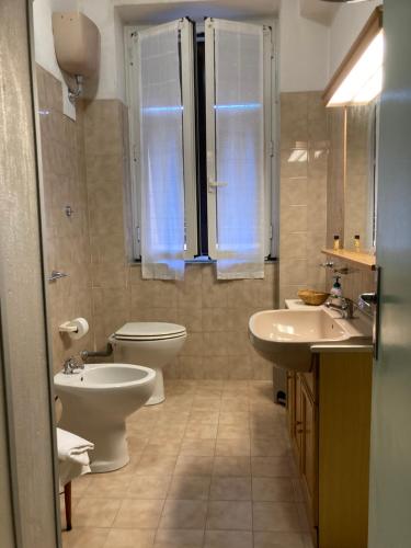 a bathroom with a toilet and two sinks and a toilet istg at Affittacamere Ponte di Marmo in Livorno