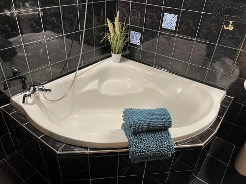 a bath tub with a blue towel sitting next to it at Apartamenty Pod Uwalonym Dębem in Jeżów Sudecki