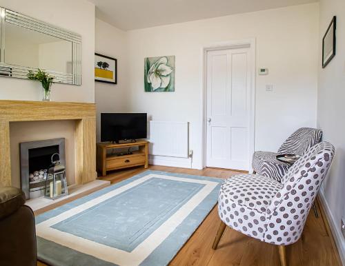 a living room with a fireplace and a tv at Kerns Cottage Stratford-upon-Avon in Stratford-upon-Avon