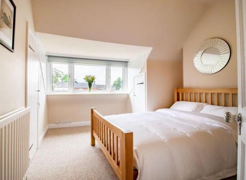 a bedroom with a large bed and a mirror at Kerns Cottage Stratford-upon-Avon in Stratford-upon-Avon