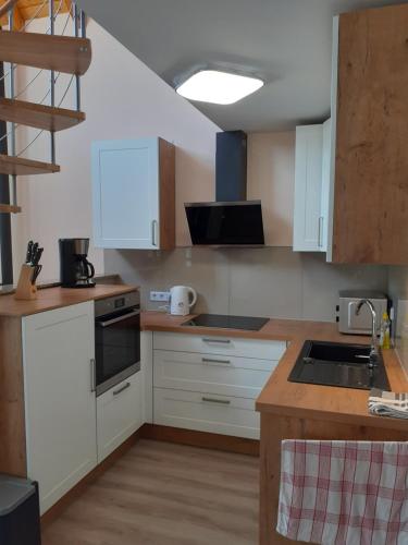 a kitchen with white cabinets and a sink at Ferienhaus am Mittelberg in Nordhausen