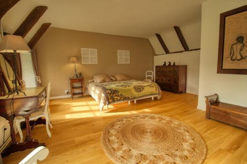 a bedroom with a bed and a table and a rug at KERBELEG, ferme-manoir du XVè siècle, chambres grand confort in Riec-sur-Bélon