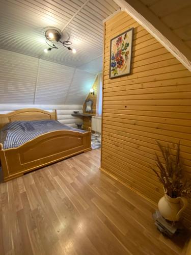 a bedroom with a bed and a wooden wall at SoloMia in Mykulychyn