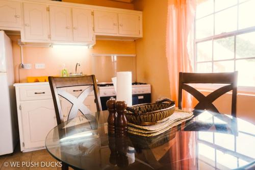 Laborie的住宿－Belle View Apartment Villa- Lilac，厨房配有玻璃桌和两把椅子