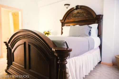 Laborie的住宿－Belle View Apartment Villa- Lilac，卧室内的一张带木制床头板的大床