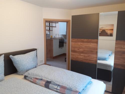 a small bedroom with a bed and a mirror at Ferienhaus am Mittelberg in Nordhausen
