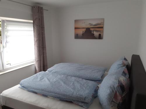 a bed with blue sheets on it in a bedroom at Ferienhaus am Mittelberg in Nordhausen