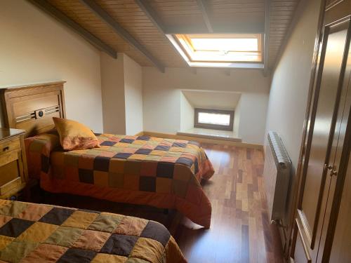 a bedroom with two beds and a window in it at Casa Rural Los Tasajos in La Horcajada