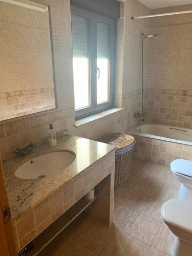 La salle de bains est pourvue d'un lavabo, de toilettes et d'une baignoire. dans l'établissement Casa Rural Los Tasajos, à La Horcajada