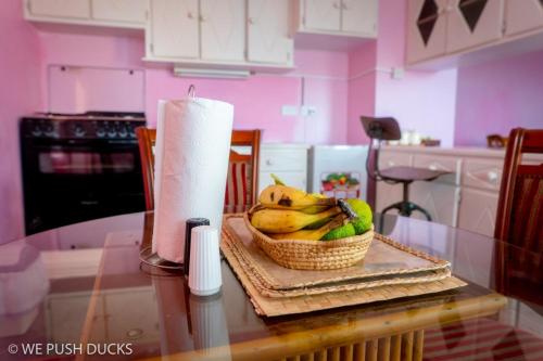una cesta de plátanos en una mesa con un rollo de toallas de papel en Belle View Apartment Villa - Hibiscus en Laborie