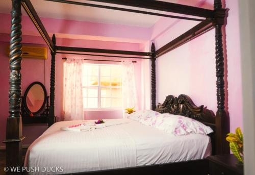 una camera con letto a baldacchino e finestra di Belle View Apartment Villa - Hibiscus a Laborie