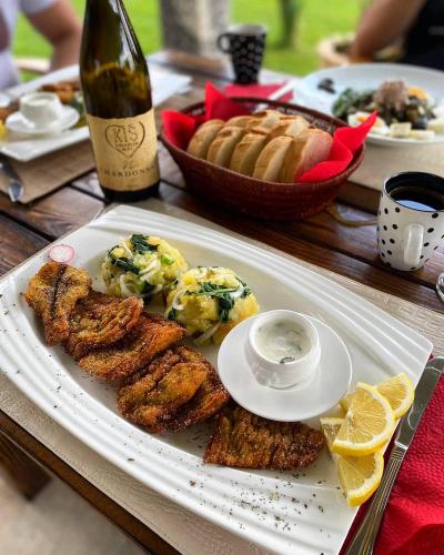 a plate of food on a table with a bottle of wine at Drinska laguna in Banja Koviljača