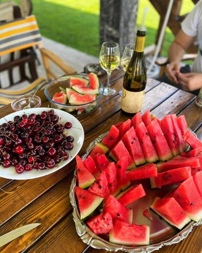 a table with a plate of fruit and a bottle of wine at Drinska laguna in Banja Koviljača