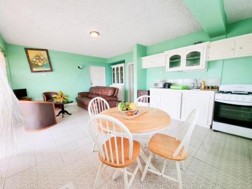uma cozinha e sala de estar com mesa e cadeiras em Belle View Apartment Villa - Cactus em Laborie