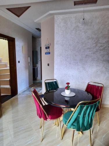 a dining room with a black table and chairs at DARY in Fès
