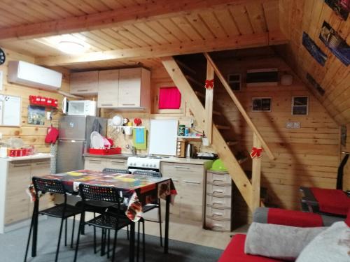 a kitchen with a table and a staircase in a room at Brvnara Orfej in Gornje Pale