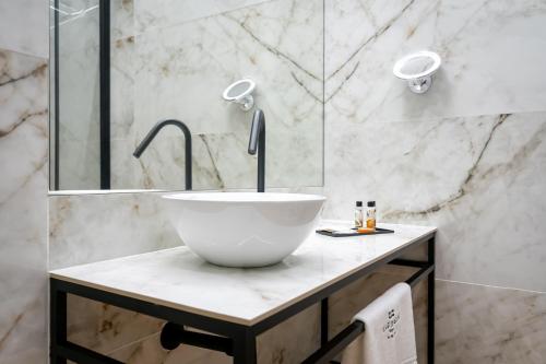 a bathroom with a bowl sink on a counter at Flag Design Hotel in Viana do Castelo