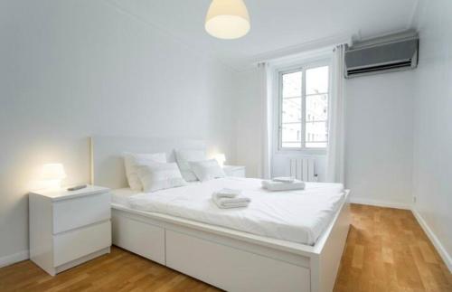 een witte slaapkamer met een groot wit bed en een raam bij BIG WHITE in Nice