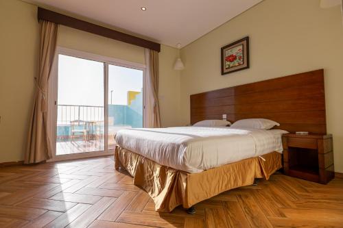 a bedroom with a large bed and a large window at Al Jar Resort - Families Only in Rayyis