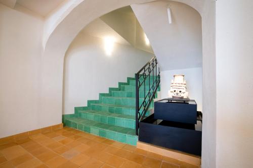 uma escada num edifício com uma escada verde em William Hotel Boutique De Diseño em Taxco de Alarcón