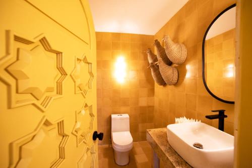 y baño con aseo blanco y lavamanos. en William Hotel Boutique De Diseño en Taxco de Alarcón